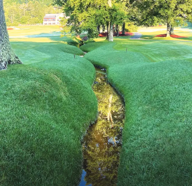 A stream on a golf course with its slopes reinforced by ShoreSOX solutions.