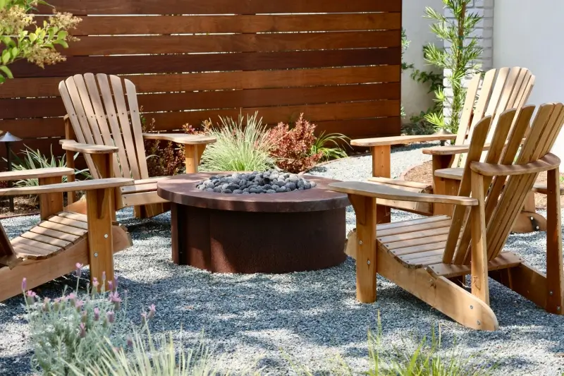 Fire pit area with chairs on top of pea gravel.